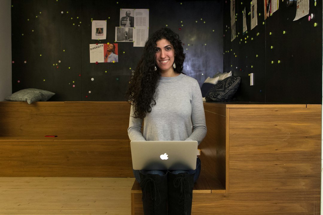 a woman standing in front of a laptop computer