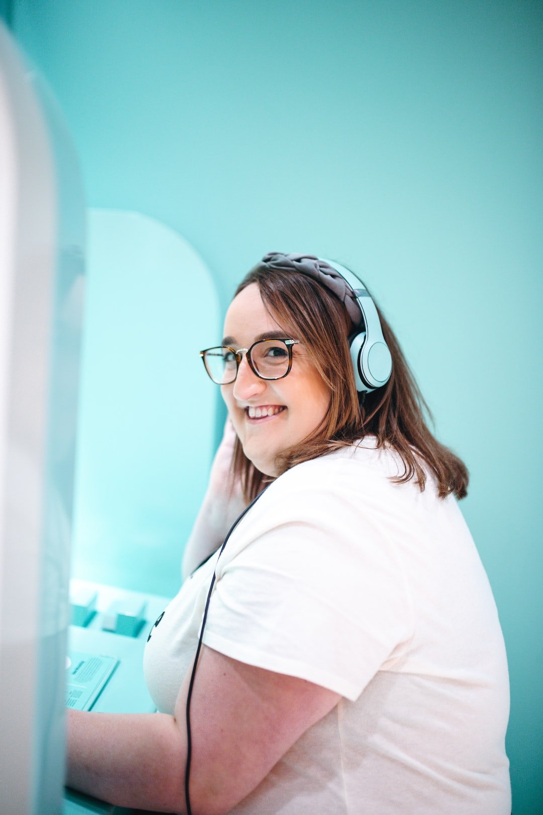 woman in white T-shirt using blue headphones